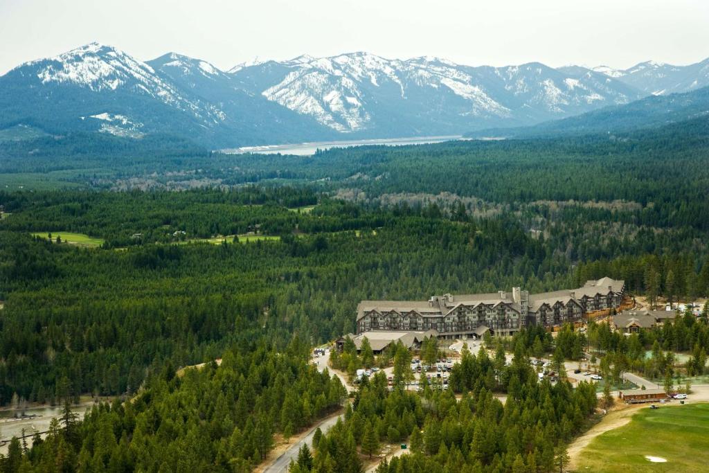 An aerial view of a large resort in a mountain valley, surrounded by trees