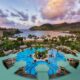 The view of a large pool and a beach with mountains on an island at one of the best resorts on the West Coast