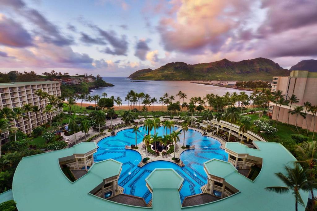 The view of a large pool and a beach with mountains on an island at one of the best resorts on the West Coast