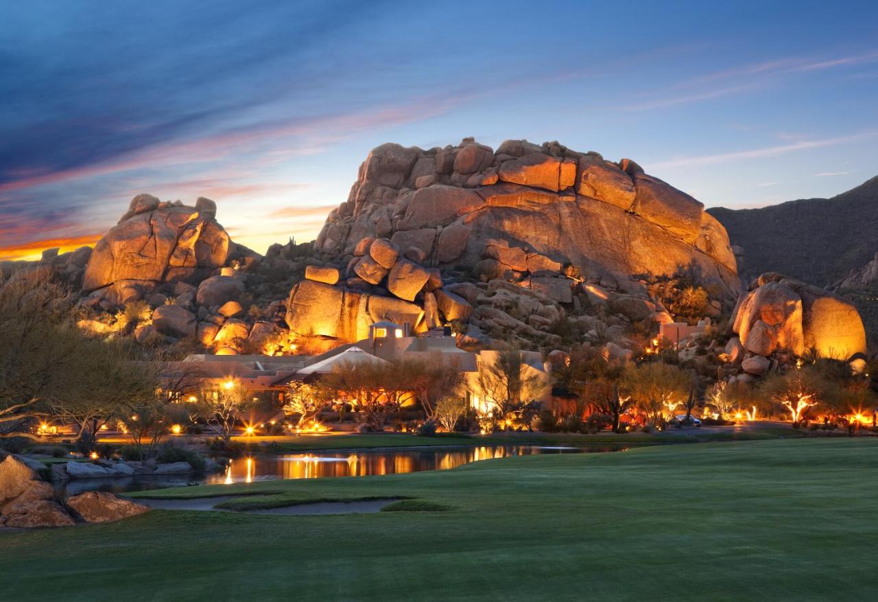 huge boulders surrounded the Boulders Resort and Spa with a pond and green grass in the foreground