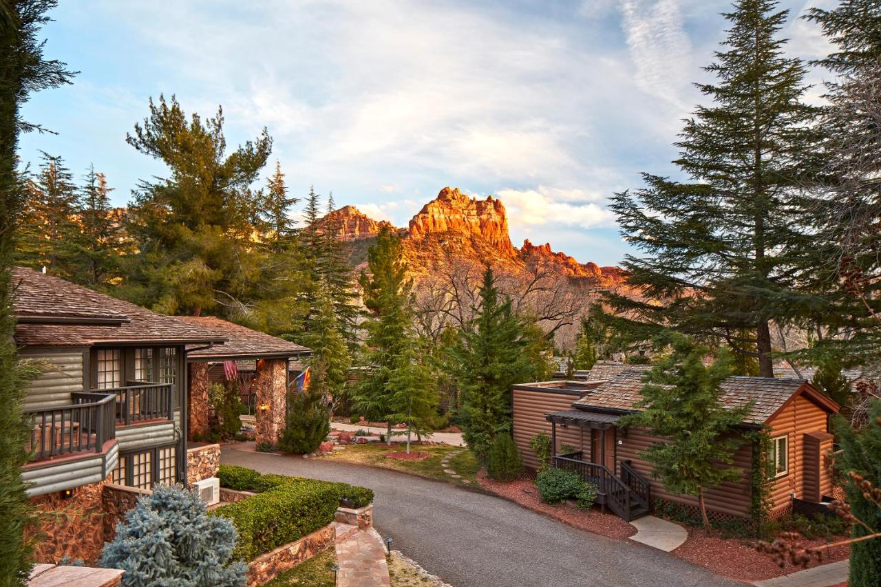 cabins amidst the trees on the L'Auberge de Sedona property with Sedona's red rocks in the background