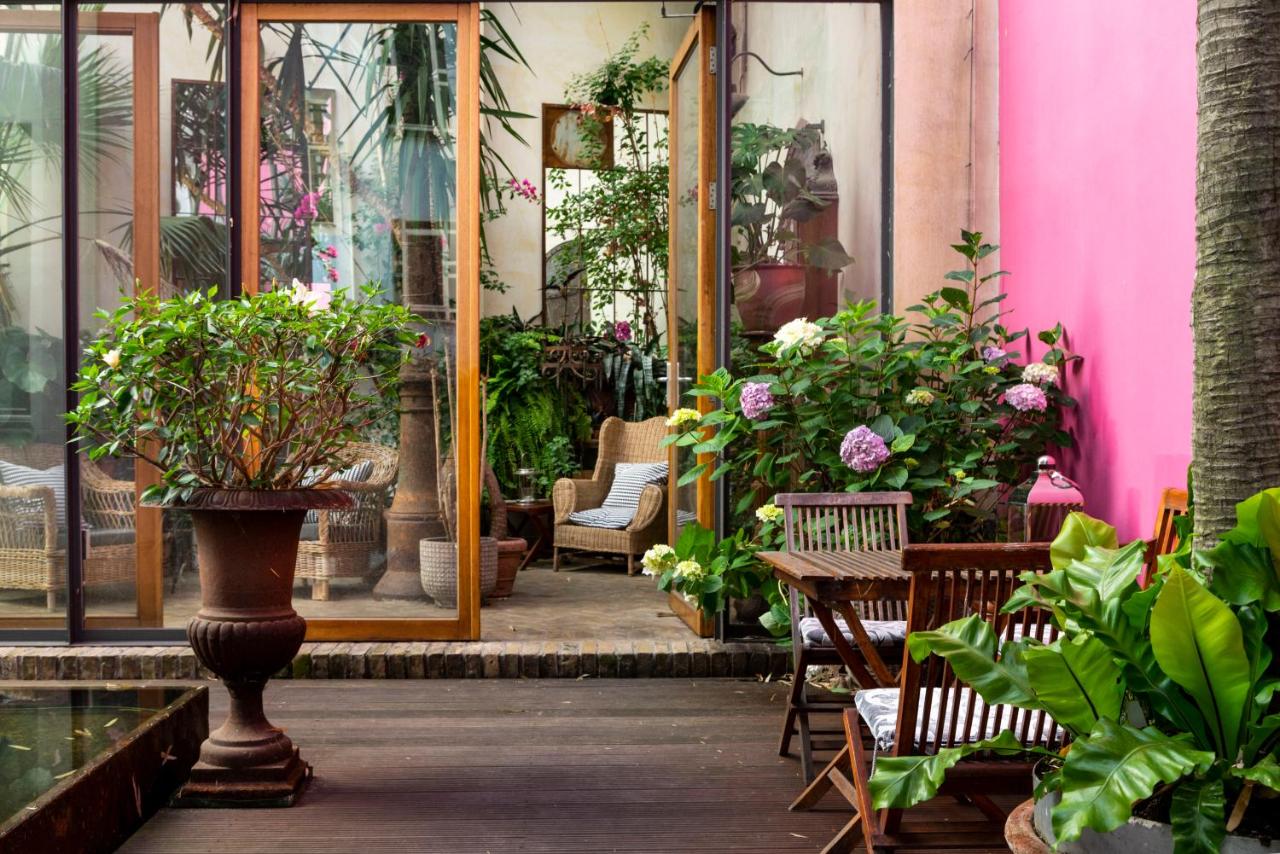 Garden patio with seating and lot of plants.