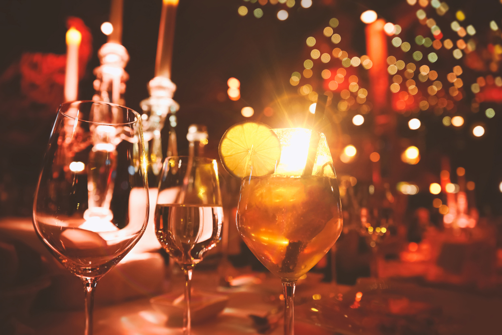 Table of cocktails in a red lit bar.