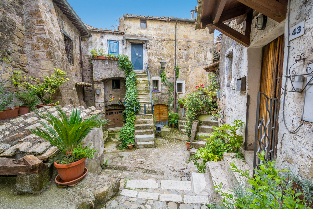 Scenic stone alleyway with many plants and stairs.