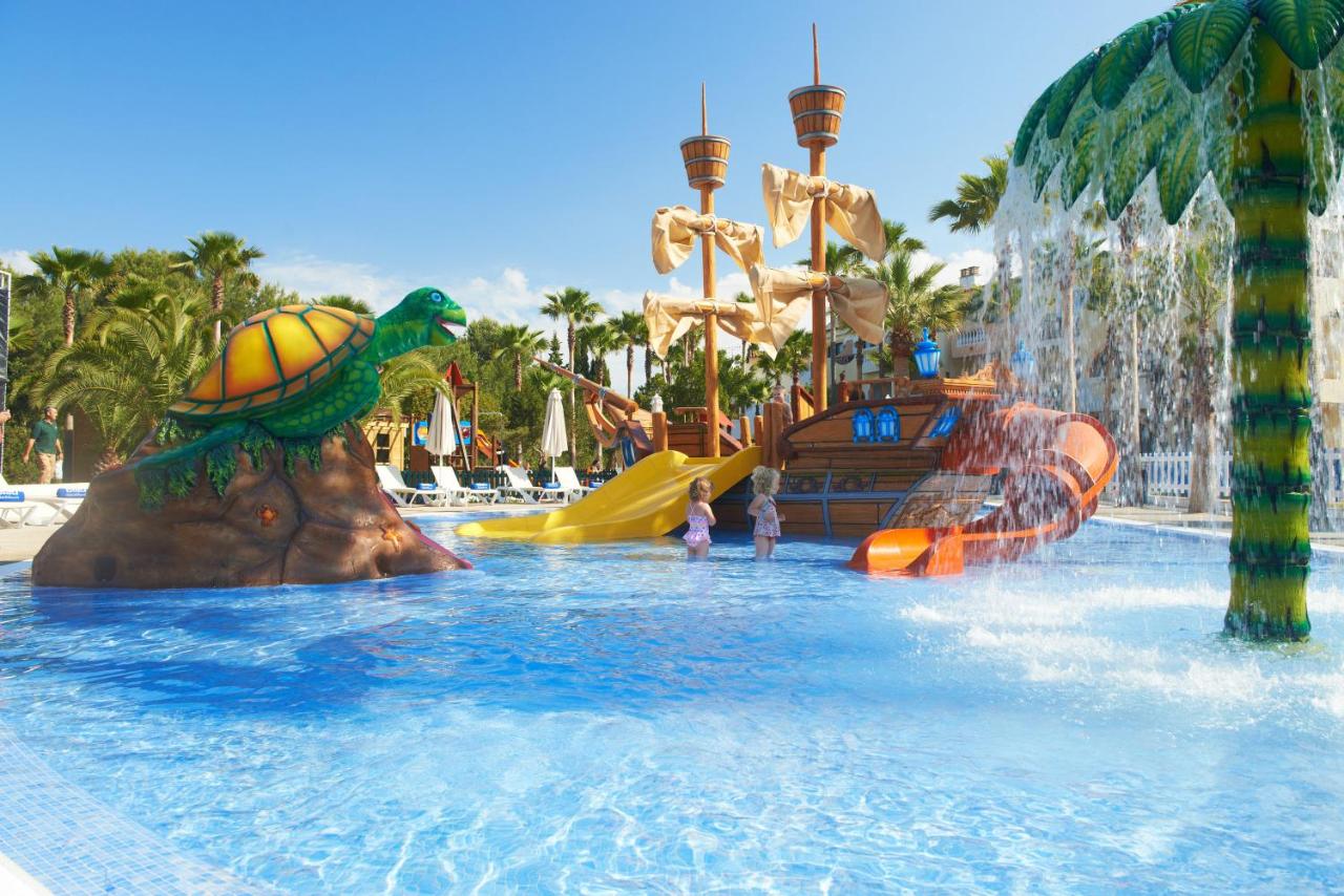 A pirate ship and a large rock with a sea turtle on it in the middle of a splash pad for kids at one of the best all inclusive resorts for families