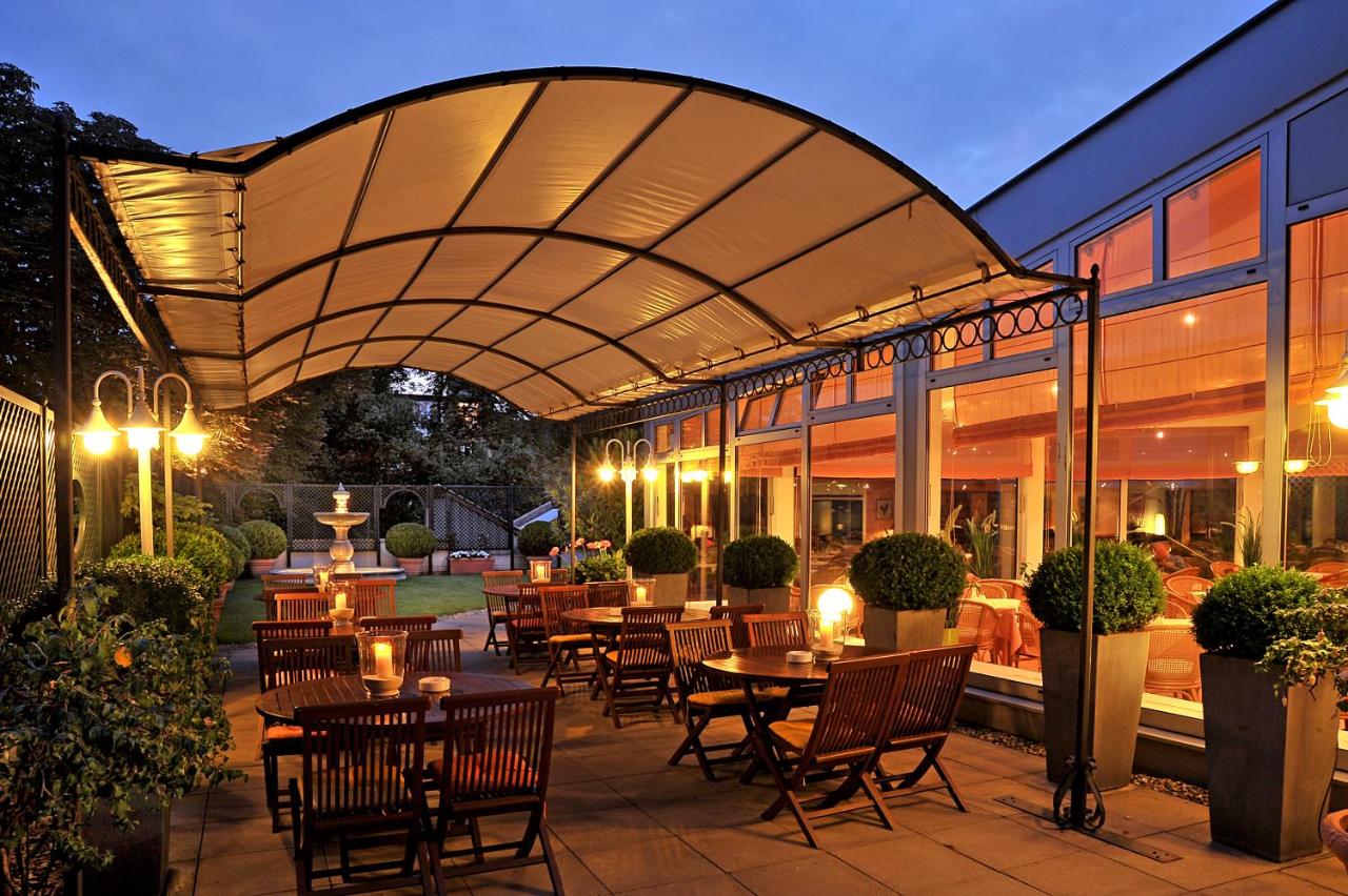 Covered patio next to a garden outside of the Hotel Ludwig van Beethoven at night.
