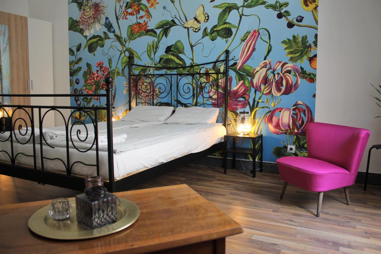 Simple room at Pension Wienderland with colorful mural behind the bed.