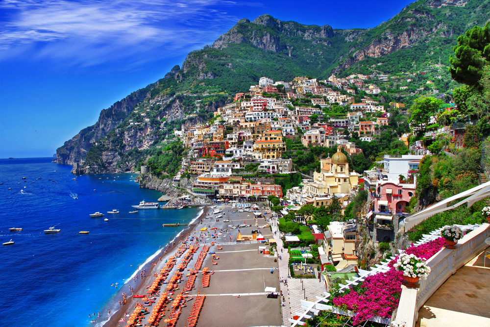 View looking down at the beach of Positano under the town tucked into the hills.