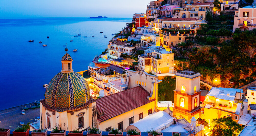 View of Positano at dusk on the coast after planning a trip to Italy