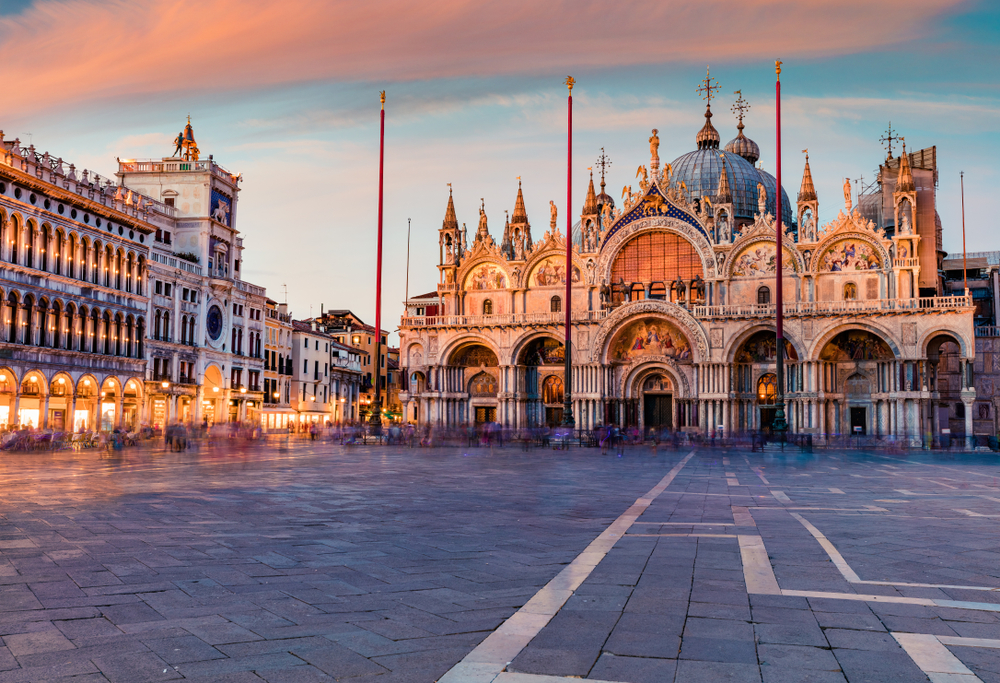 Pink sunset over the grand Saint Mark’s Basilica in the square.
