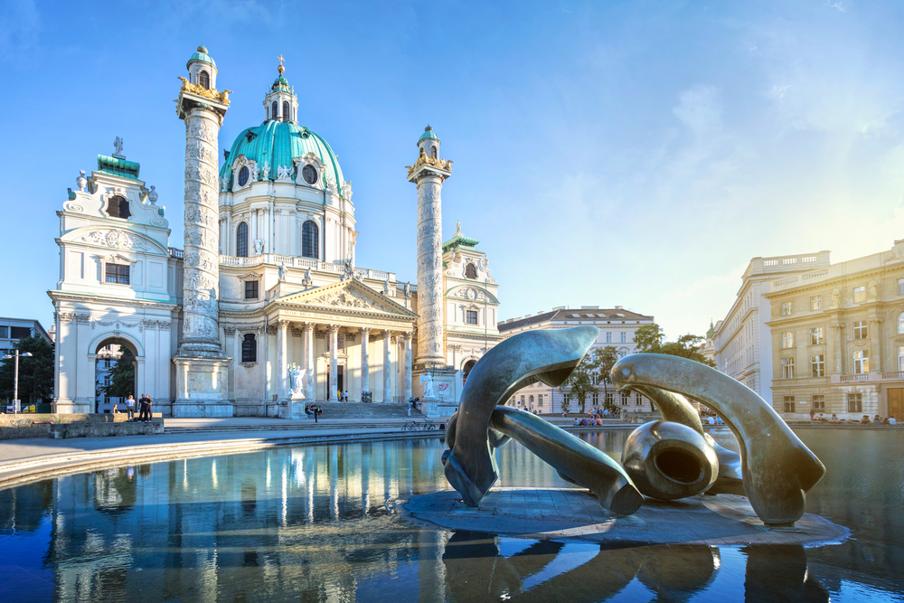 Fountain in front of the while St. Charles Church during golden hour.