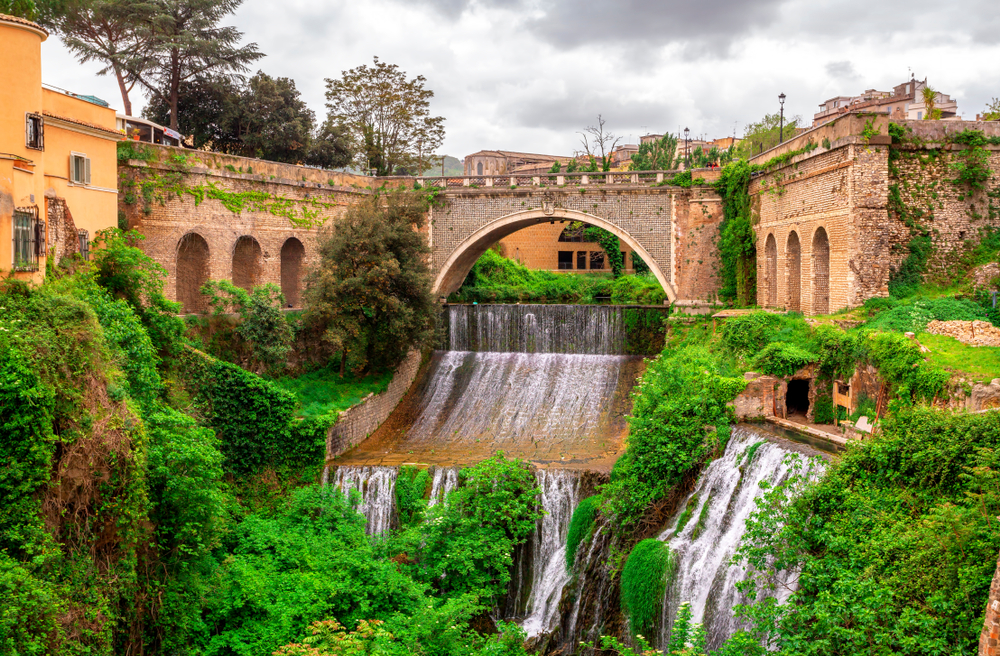 Waterfalls and a stone bridge at Villa Gregoriana in Tivloi, one of the best day trips from Rome.