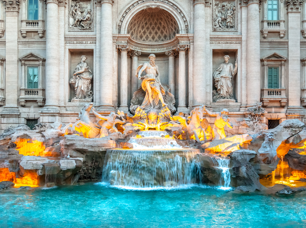 Detail shot of the statues over the Trevi Fountain bathed in golden, morning light.