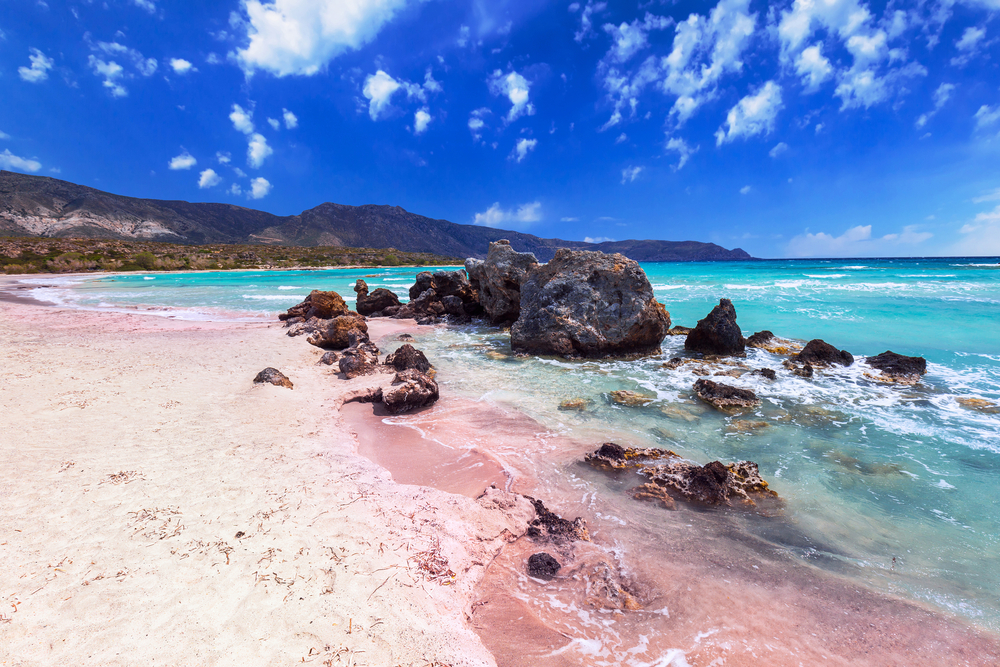 Elafonissi Beach, as shown in this photo with shallow waters, pink sand, and stunning blue skies, is one of the best beaches in the world.