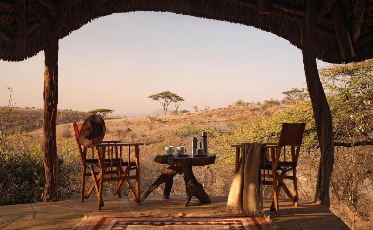 Looking out at the plains of Africa from a tent with two chairs and a small table at one of the best all inclusive resorts for families