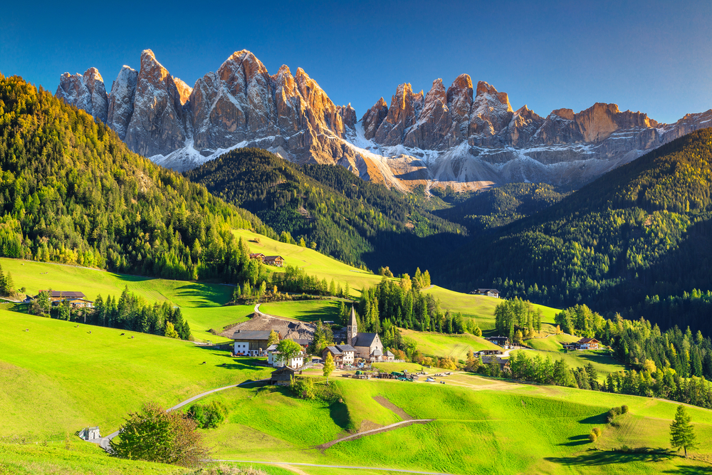 The Dolomites hover in the background-- white with snow and tall and pointy-- while the land below it is bright green in Italy in May.