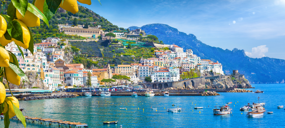 On the coast, building and a lemon tree look over the blue waters in Italy in May.