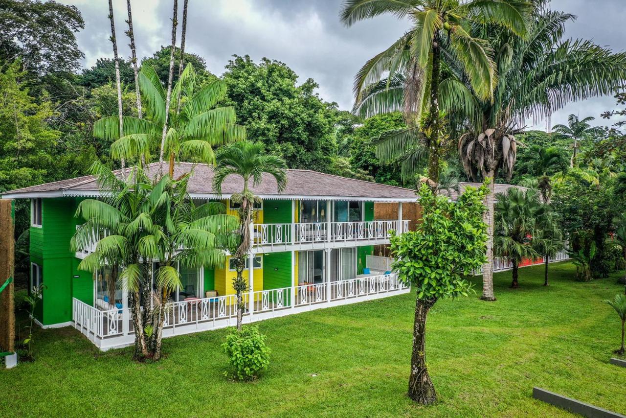 A bright green and yellow two story lodge surrounded by lush greenery in Costa Rica at one of the best all inclusive resort for families