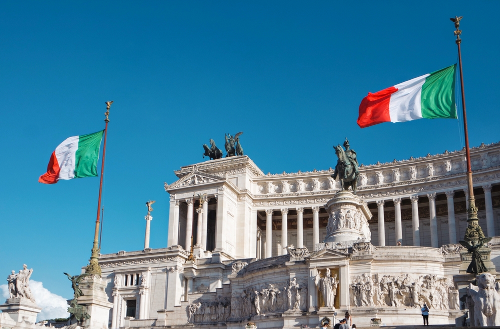 Cloudless day at the Altar of the Fatherland with many statues and Italy flags.
