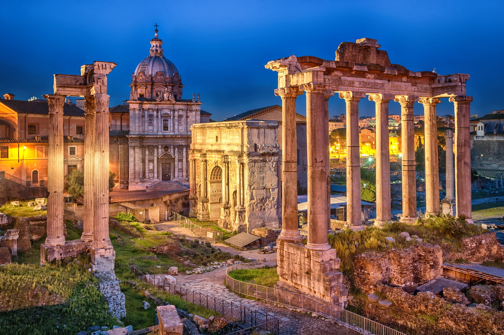 The Roman Forum lit up at night.