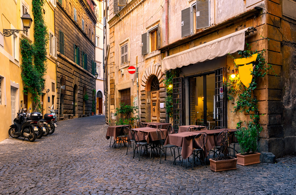 A restaurant with tables in an alley in Rome.