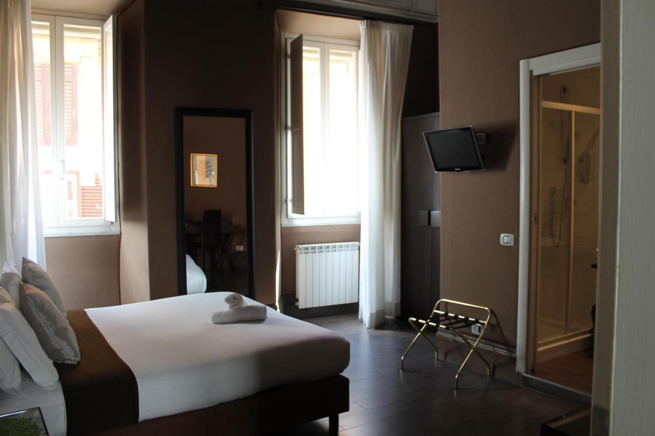 Simple hotel room at Relais Palazzo Taverna with a bed and windows.