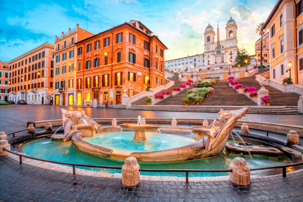 Sunrise at the Spanish Steps with a fountain in the plaza during 2 days in Rome.