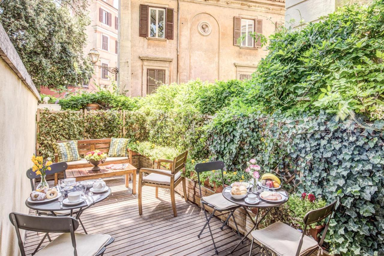 Terrace with seating and breakfast surrounded by vines.