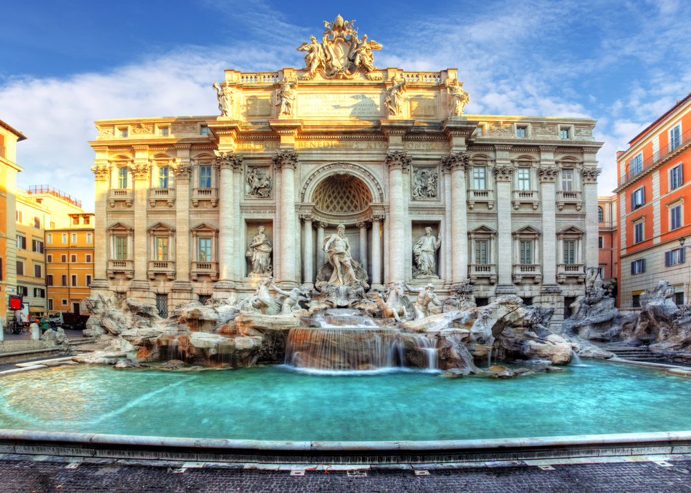 Golden hour light shining on the Trevi Fountain in Rome.