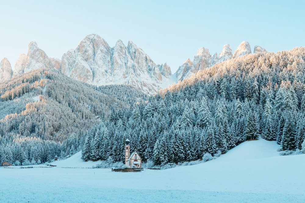 Sunny winter landscape in the morning of Dolomite Alps. St Johann Church with beautiful Dolomiti mountains. 