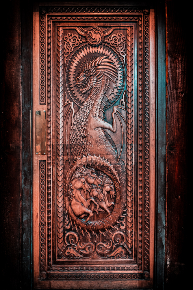 Intricately carved door featuring a dragon and horses. 