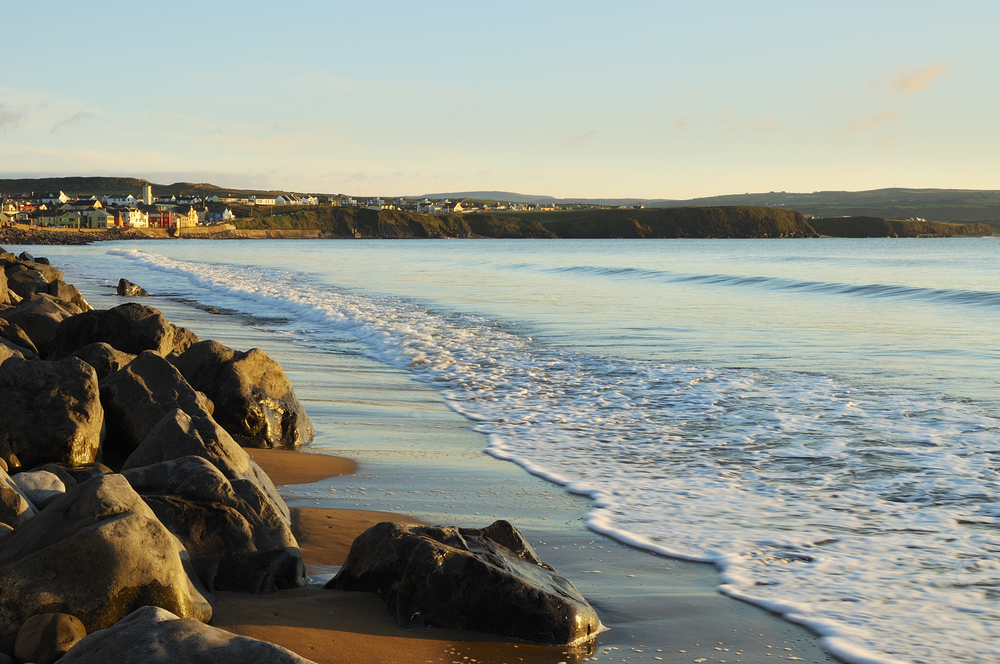 Golden hour over the tide of Lahinch Beach.