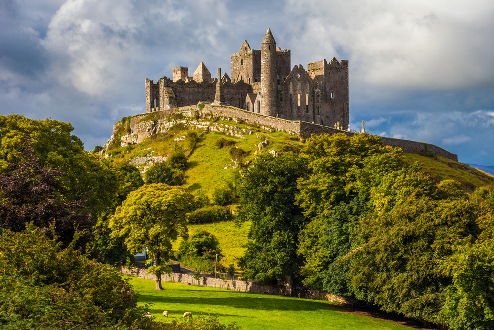 Rock of Cashel castle ruins sitting atop a green hill in Ireland.