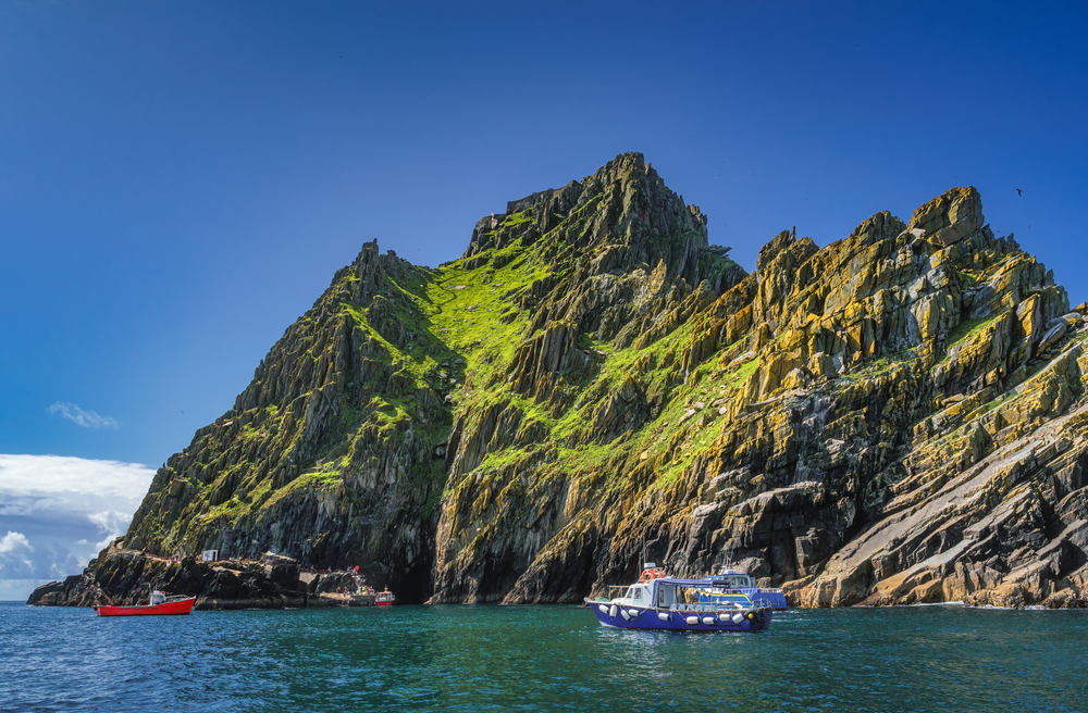 A boat near the rugged Skellig Michael rock formation.