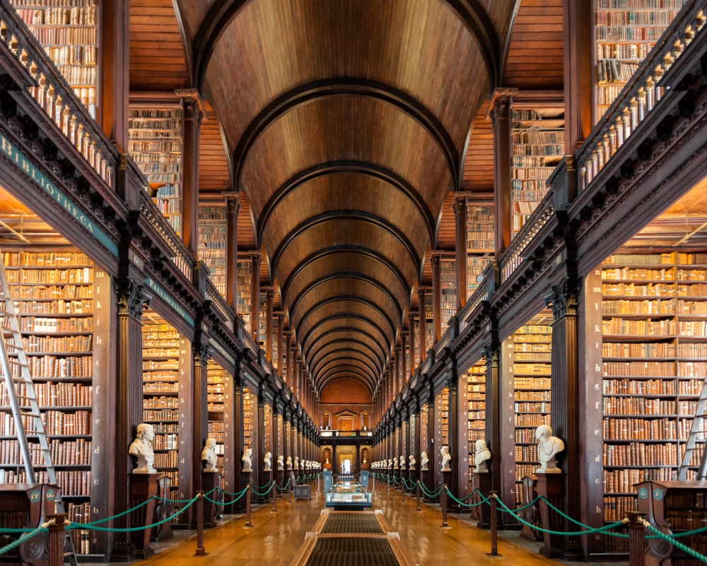 The Long Room at Trinity College full of books, busts, and high ceilings.