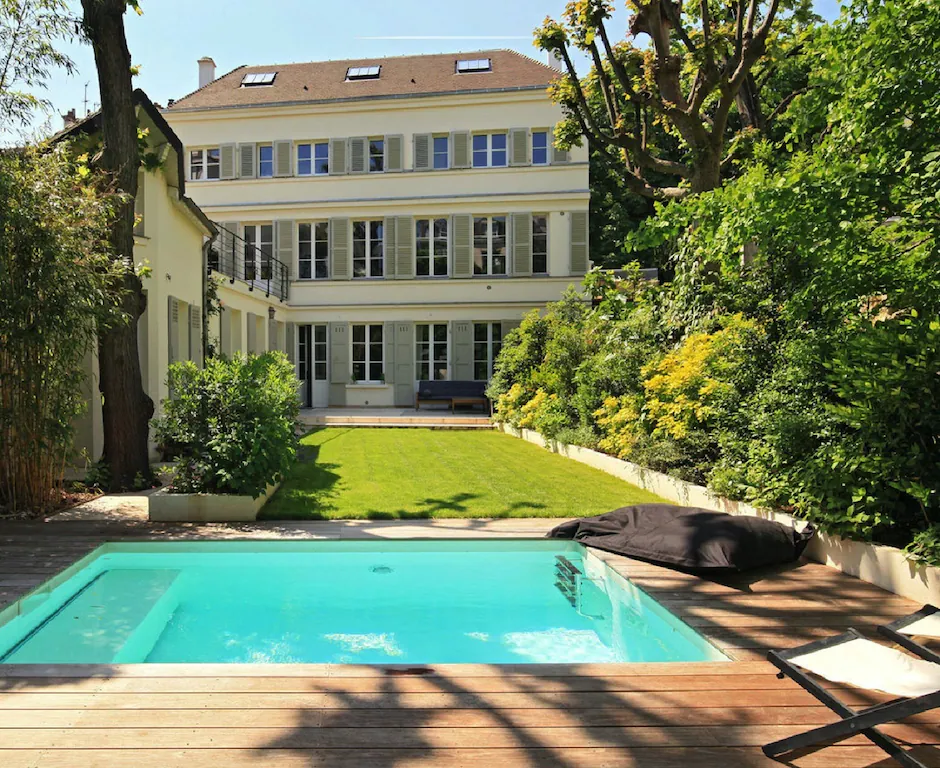 View of the amazing private pool and huge 18th century house beyond in this luxurious garden in the heart of the Latin Quarter in Paris. 