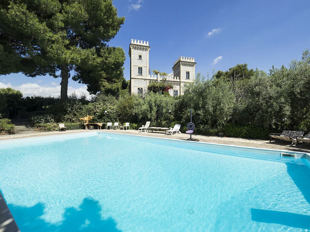 View of the turreted gothic castle seen over the private pool. This is one of the best airbnbs in Sicily for sure!