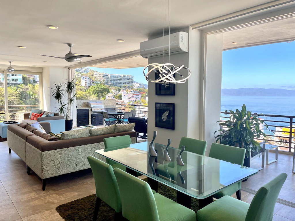View of the dining and living area and the balcony and sea view beyond of the sunset views in puerta vallarta condo. This is one of the best airbnbs in Mexico.
 