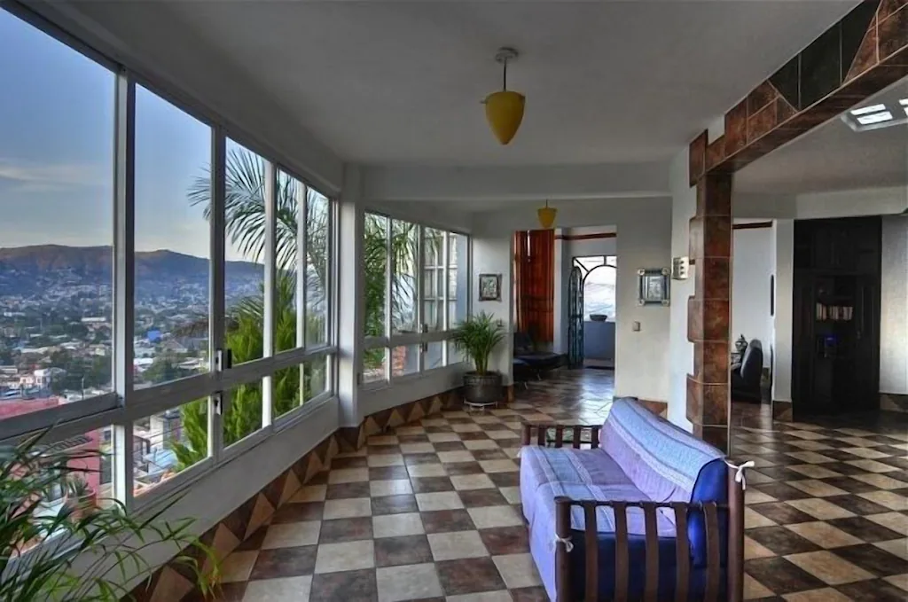 a blue couch looking out at the amazing views of Oaxaca from the huge windows 