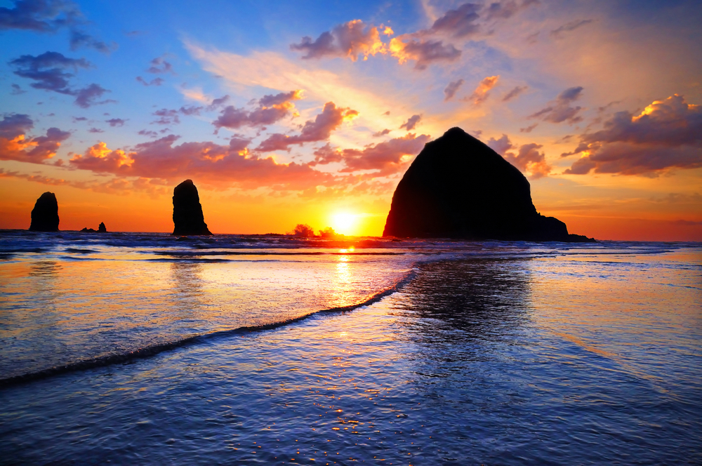 Vivid sunset over Cannon Beach, silhouetting the sea stacks.