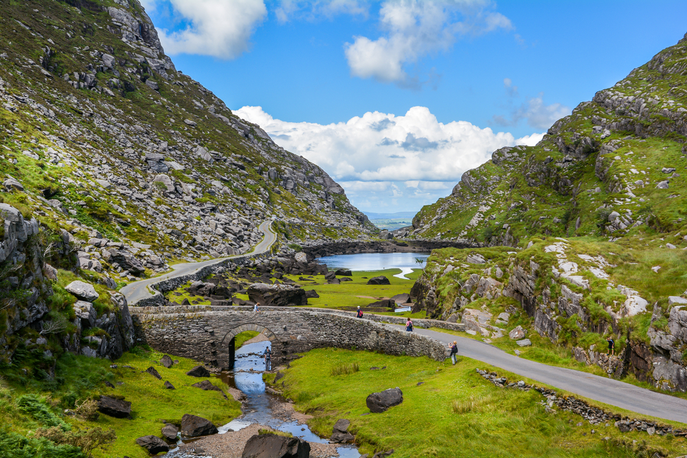 Aerial view of a stone bridge tucked in mountains on the Ring of Kerry in Ireland.