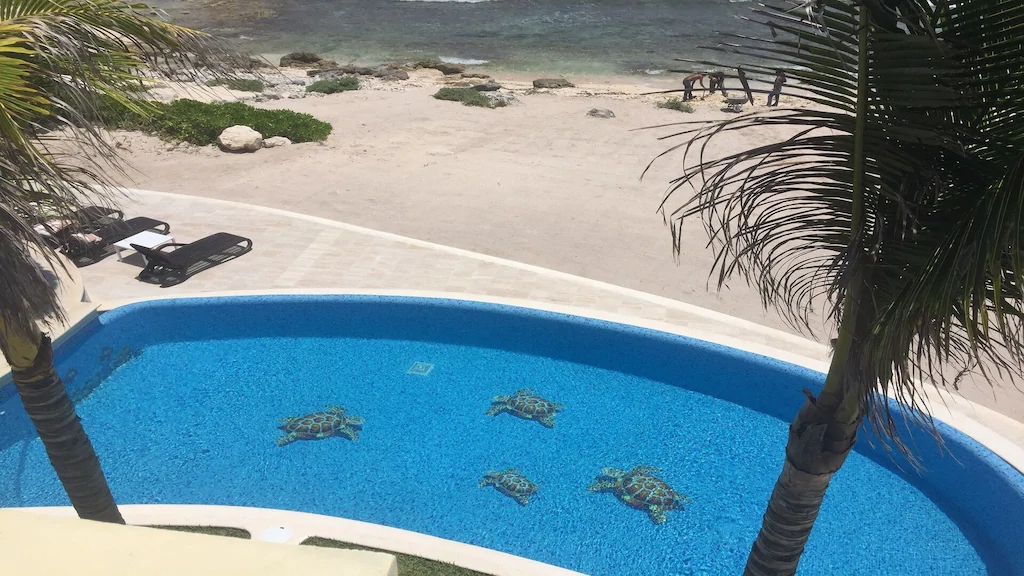 View of the private pool and sandy beach beyond of Casa Vendeval, one of the best airbnbs in Tulum 