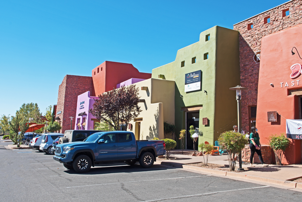 Village of Oak Creek with colourful buildings down one side of the road and a truck packed up. 