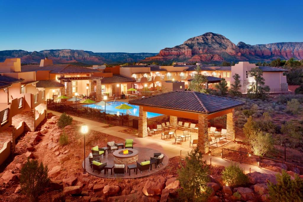 The outside seating are of a hotel with a firepit and chairs and the mountinas in the background. 