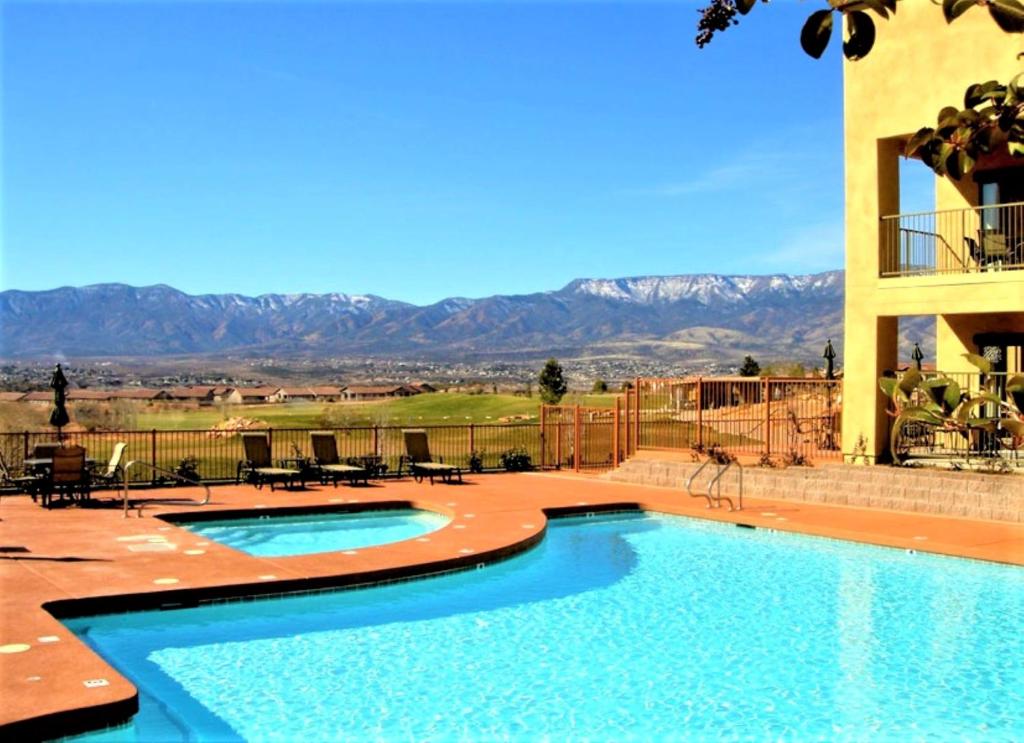 Hotel pool with grass and mountains in the distance 