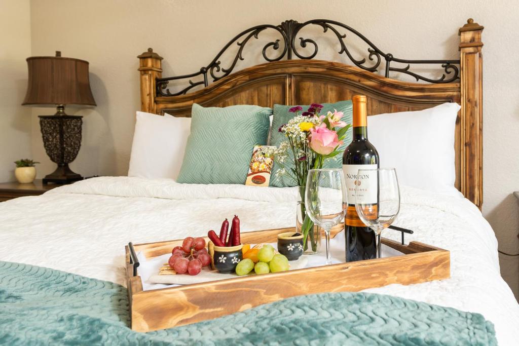 Picture of bed with wine and snacks on a tray. The article is about where to stay in Sedona 