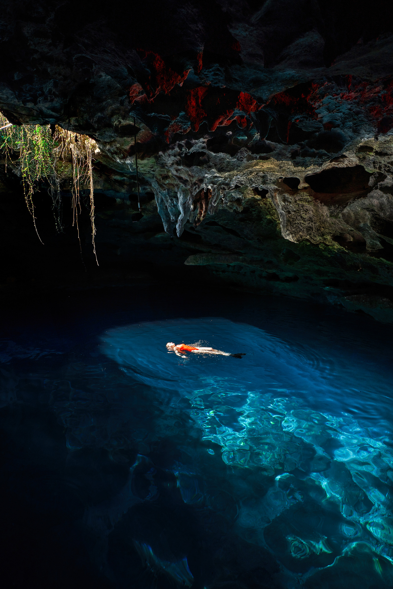 A girl in swimsuit floating in the underground cave at Devils Den one of the BEST things to do in Florida for scuba divers