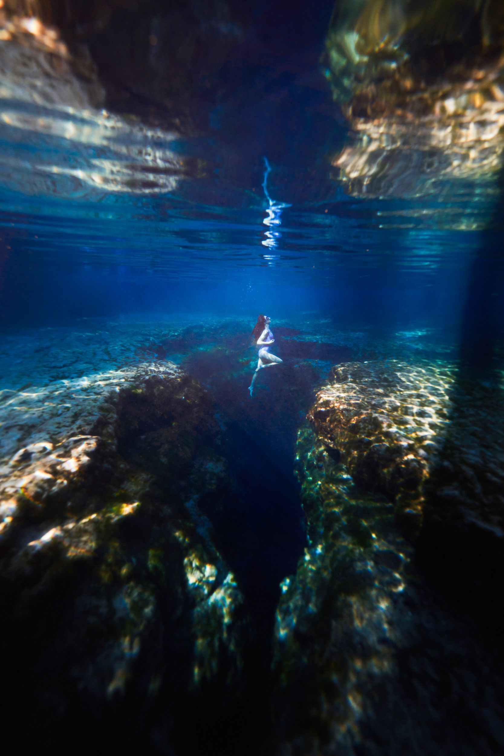 A girl underwater posing in the natural spring water at Ginnie Springs