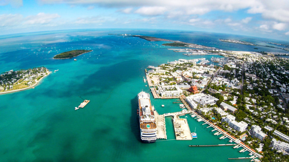 an Ariel view of Kew West with a big boat docked and beautiful blue waters 