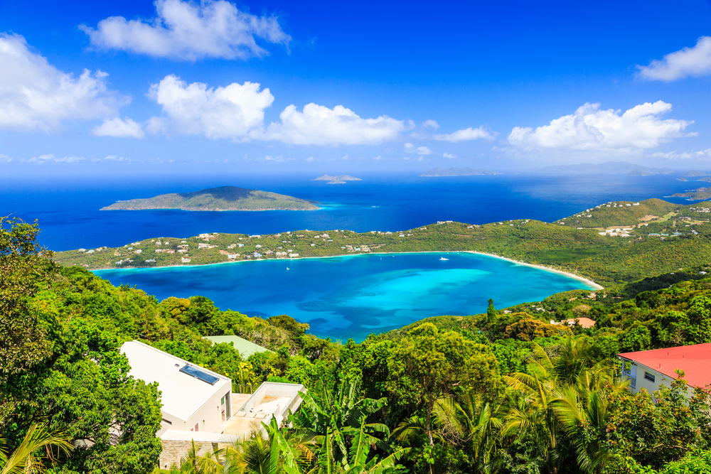 an birds eye view of st Thomas with a beautiful beach and greenery all around. visiting here is one of the best winter vacations in the USA